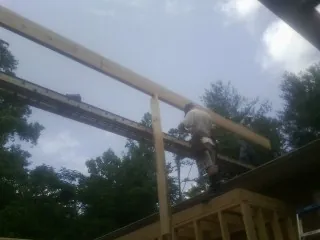 Carpenter setting a ridge beam over a new addition frame — Ice Dam Removal by Roofing Brothers in Deary