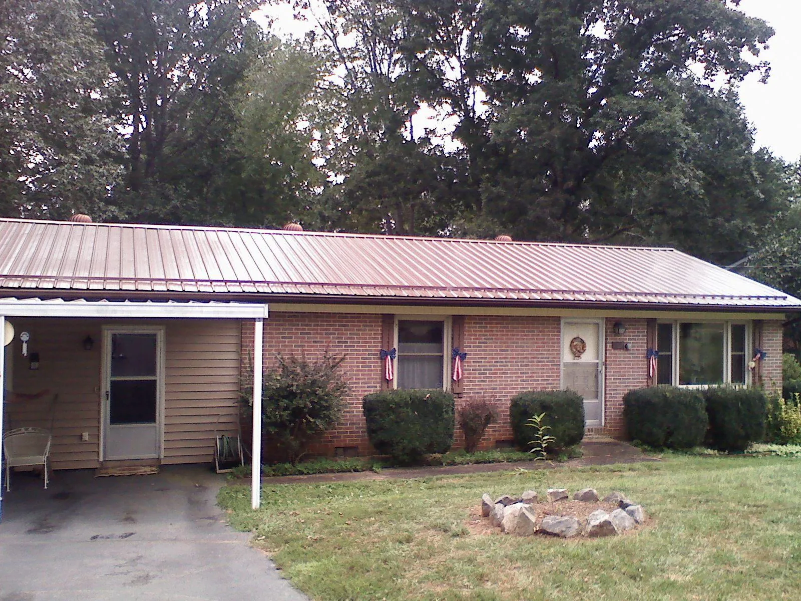 Bronze metal roof and carport on a brick ranch home — Roof Repair work by our crew in Deary